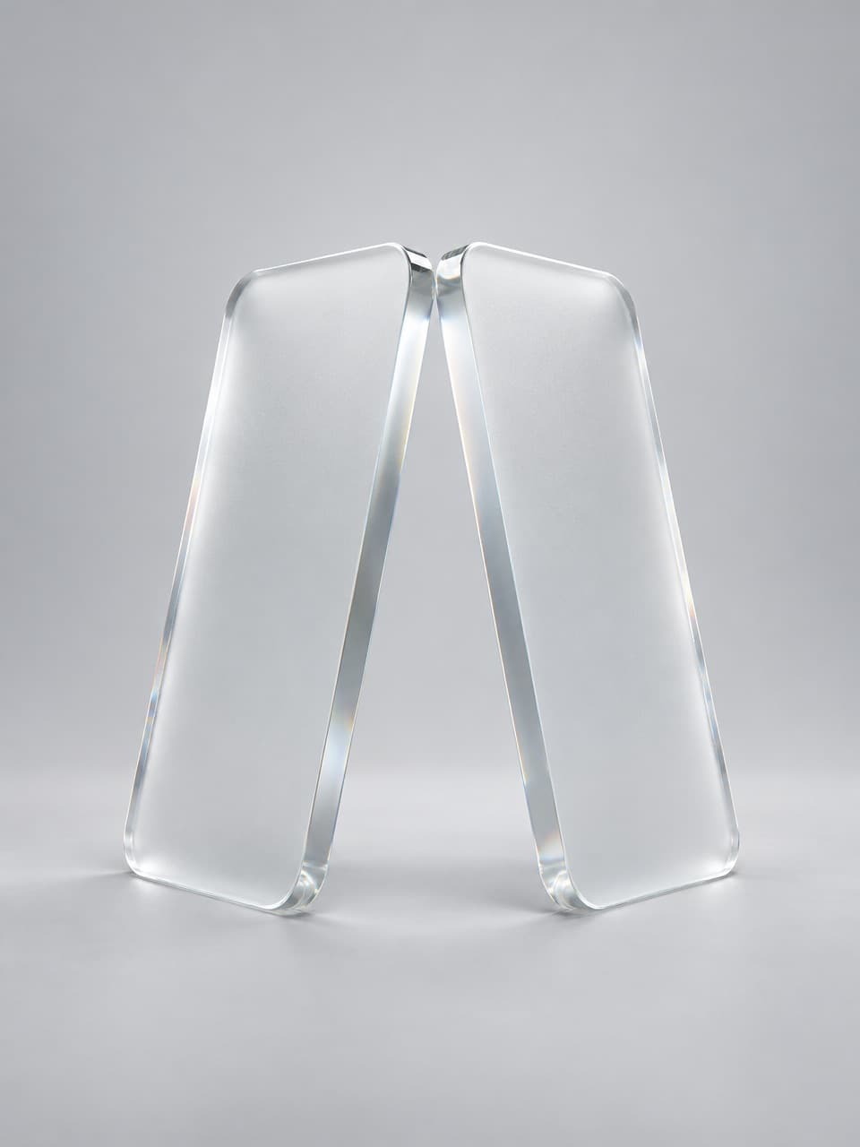 Two frosted glass slabs, shaped like phone screens, leaning together until their top edges touch.